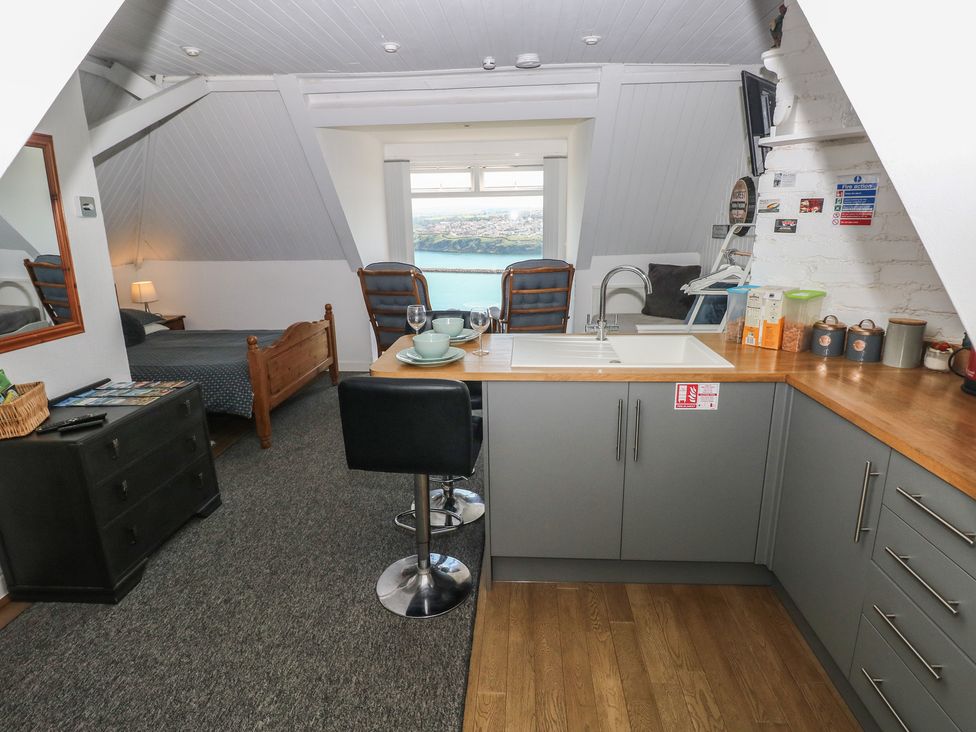 A studio with a bed and kitchen area at Seaside Steps in Goodwick