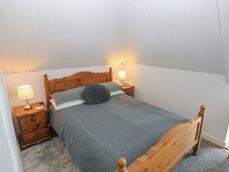 A bedroom with a bed and nightstand at Seaside Steps in Goodwick