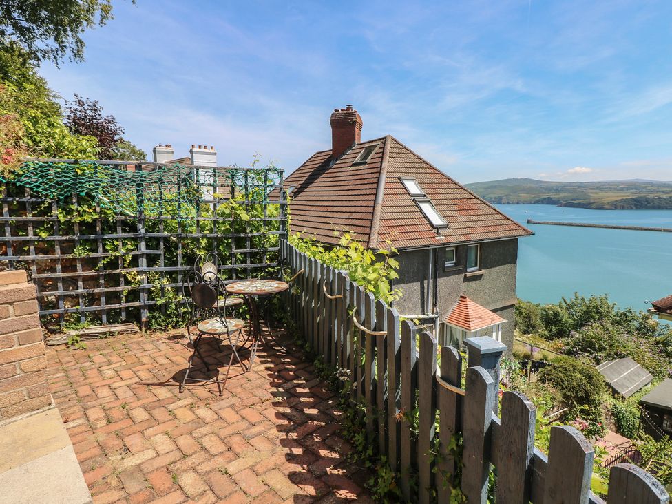 An outdoor patio with a table and chairs at Seaside Steps in Goodwick