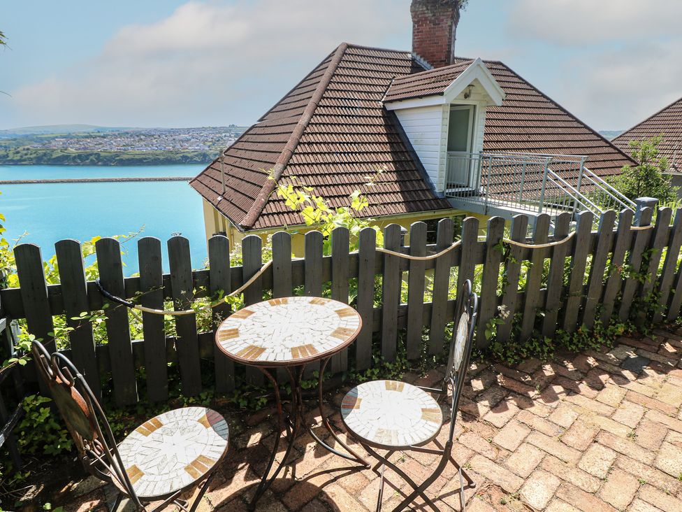 An outdoor seating area with a table and chairs at Seaside Steps in Goodwick