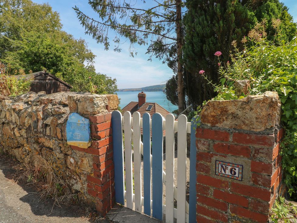 A gate and stone wall leading to a house at Seaside Steps in Goodwick