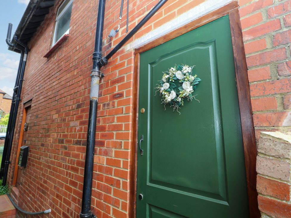 A green door with a wreath outside a building at Daisy Cottage 22 Chalkpit Terrace Dorking