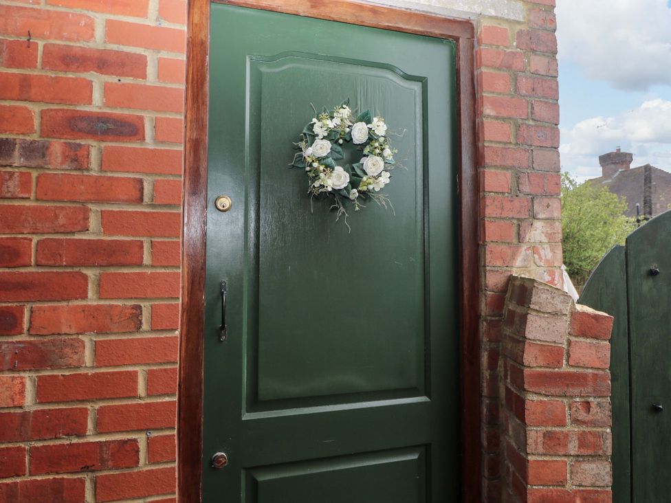 A green door with a wreath at the entrance at Daisy Cottage 22 Chalkpit Terrace Dorking
