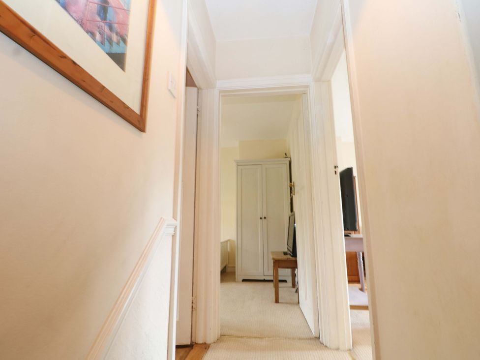 A hallway with a wardrobe and television at Daisy Cottage 22 Chalkpit Terrace in Dorking