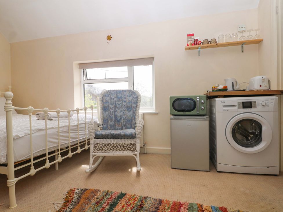 A bedroom with a bed and various appliances at Daisy Cottage 22 Chalkpit Terrace in Dorking