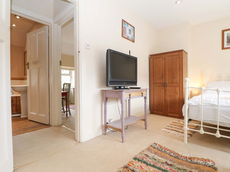 A bedroom with a bed and television at Daisy Cottage 22 Chalkpit Terrace, Dorking