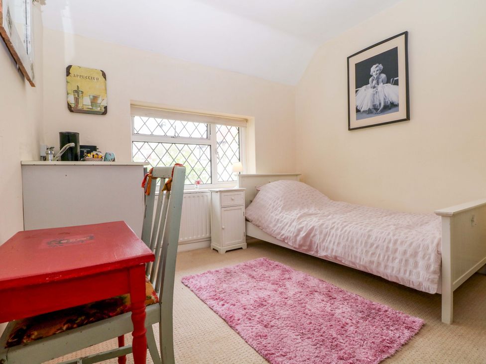 A bedroom with a bed and desk at Daisy Cottage 22 Chalkpit Terrace in Dorking
