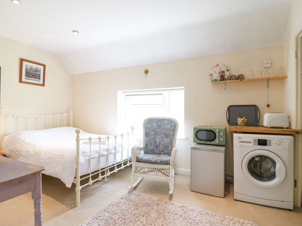 A bedroom with a bed and appliances at Daisy Cottage in Dorking