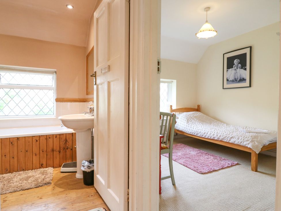A bathroom with a bathtub and sink at Daisy Cottage in Dorking