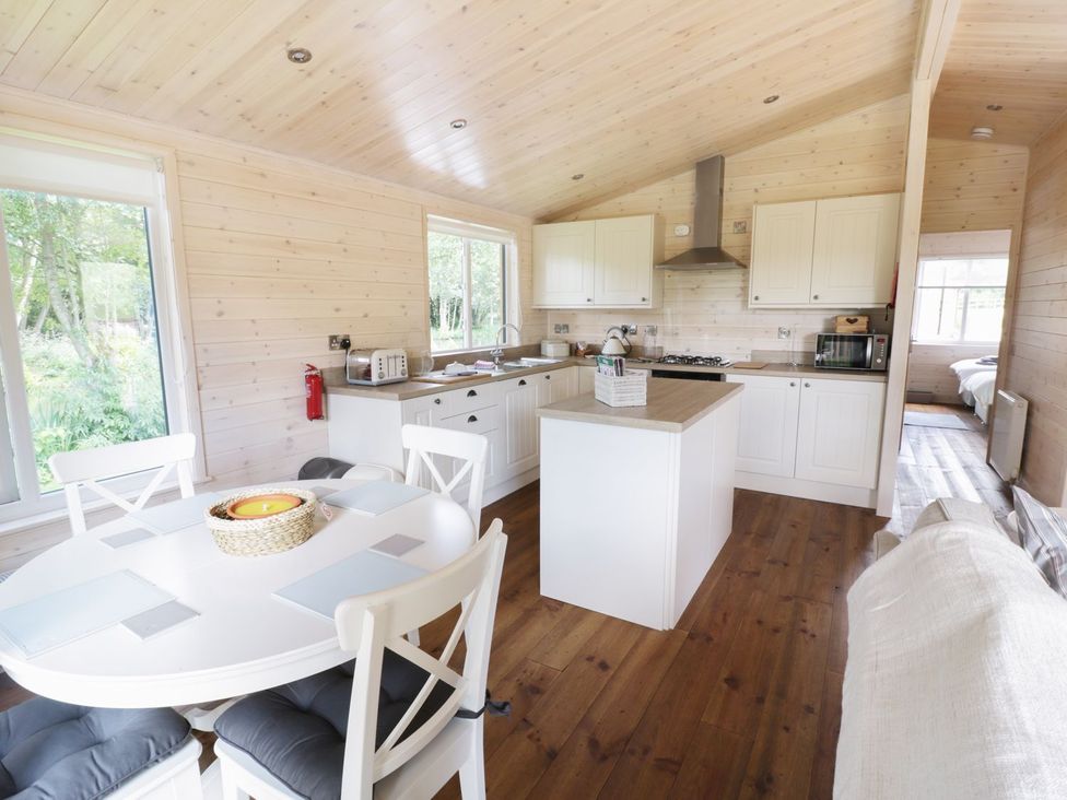 A kitchen with a dining table and appliances at Skylark in Ross-on-Wye