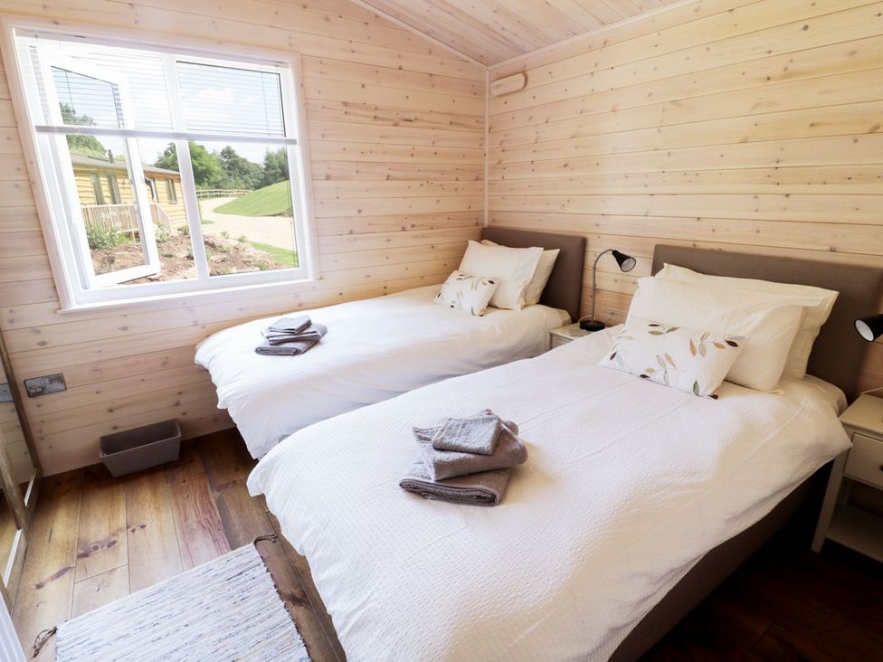 A bedroom with two beds and a window at Skylark in Ross-on-Wye