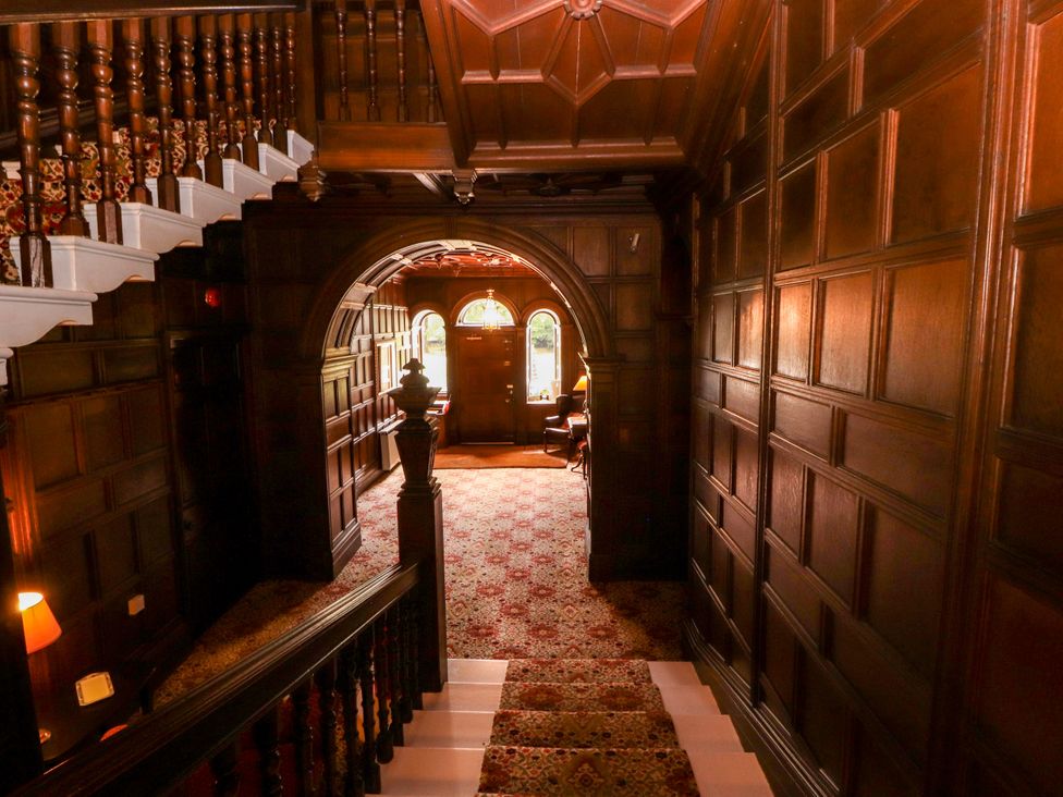 A hallway with a staircase and wooden paneling at Rochester Apartment in Orton