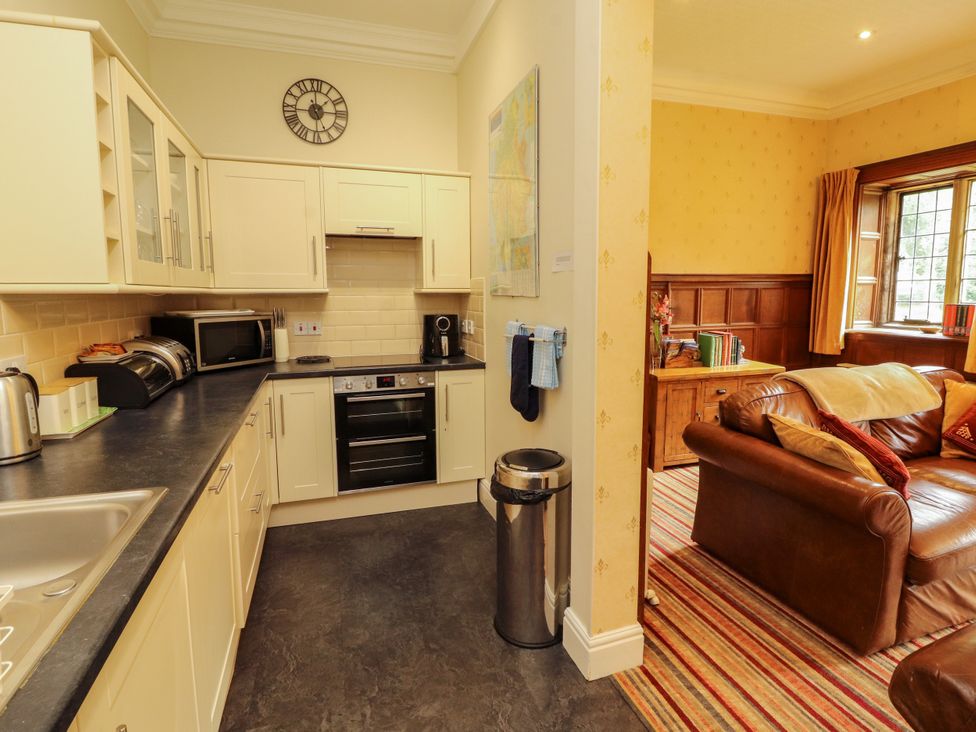 A kitchen with appliances and furniture at Rochester Apartment in Orton
