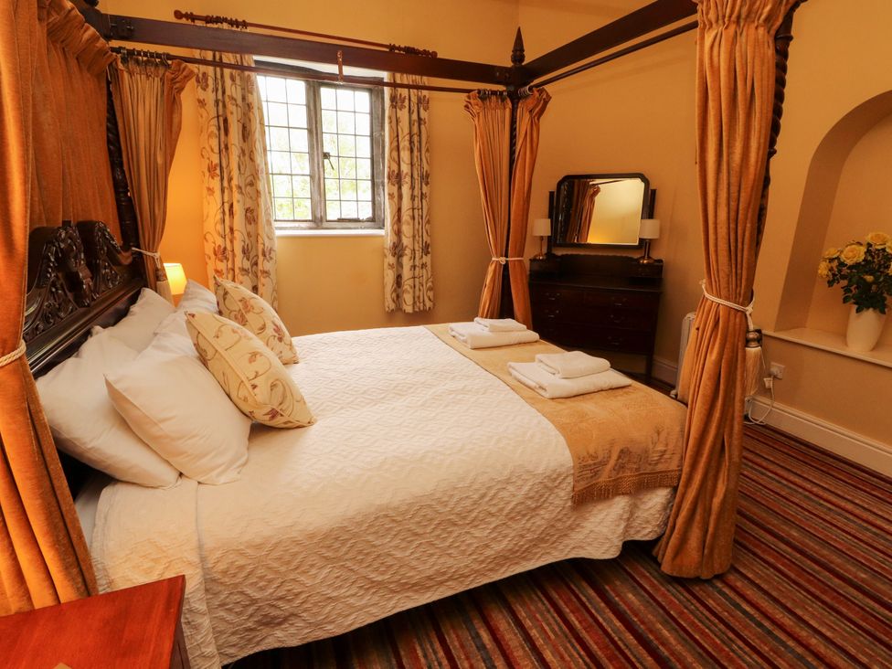 A bedroom with a four-poster bed and mirror at Rochester Apartment in Orton
