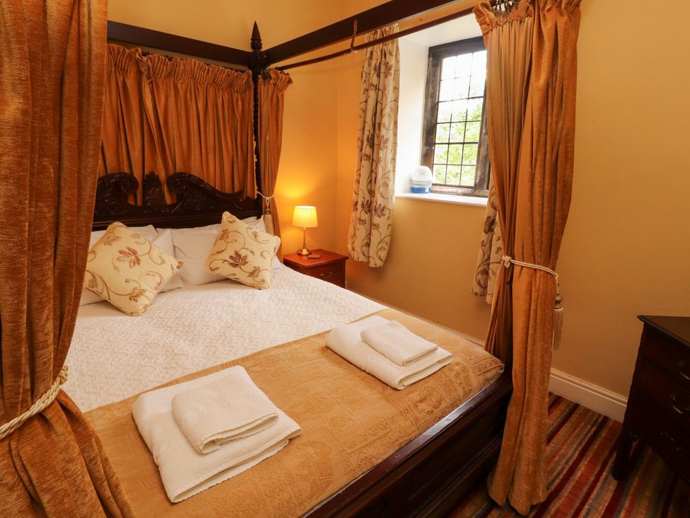 A bedroom with a four-poster bed and window at Rochester Apartment in Orton