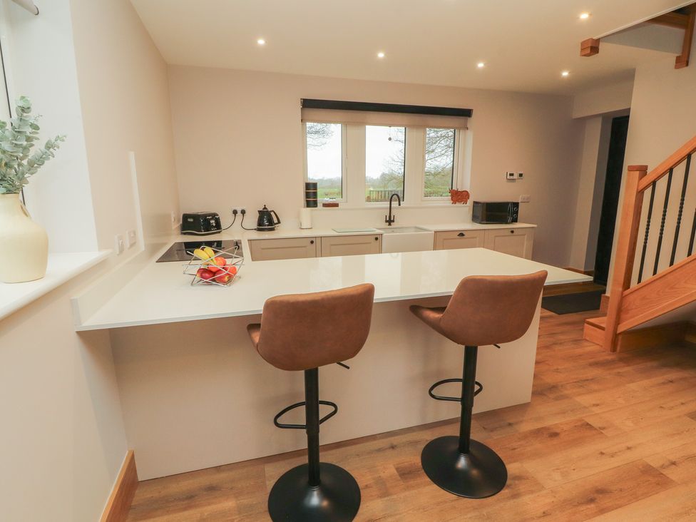 A kitchen with bar stools and a sink at The Gate House Annexe Cockermouth