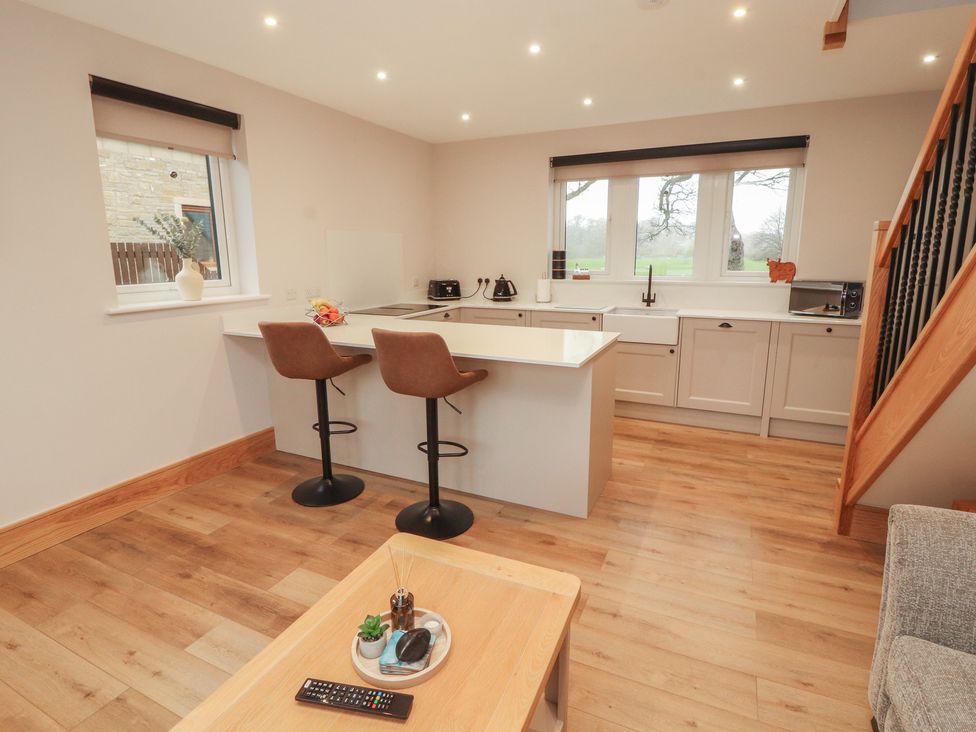 A kitchen with bar stools and a sink at The Gate House Annexe Cockermouth