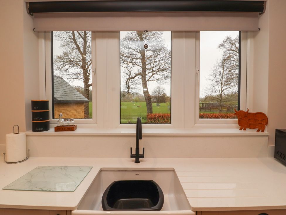 A kitchen with a sink and window overlooking a garden at The Gate House Annexe Cockermouth