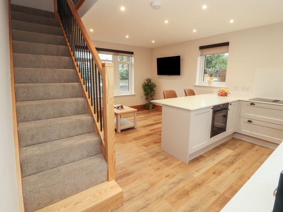 A kitchen with a staircase and tv at The Gate House Annexe in Cockermouth
