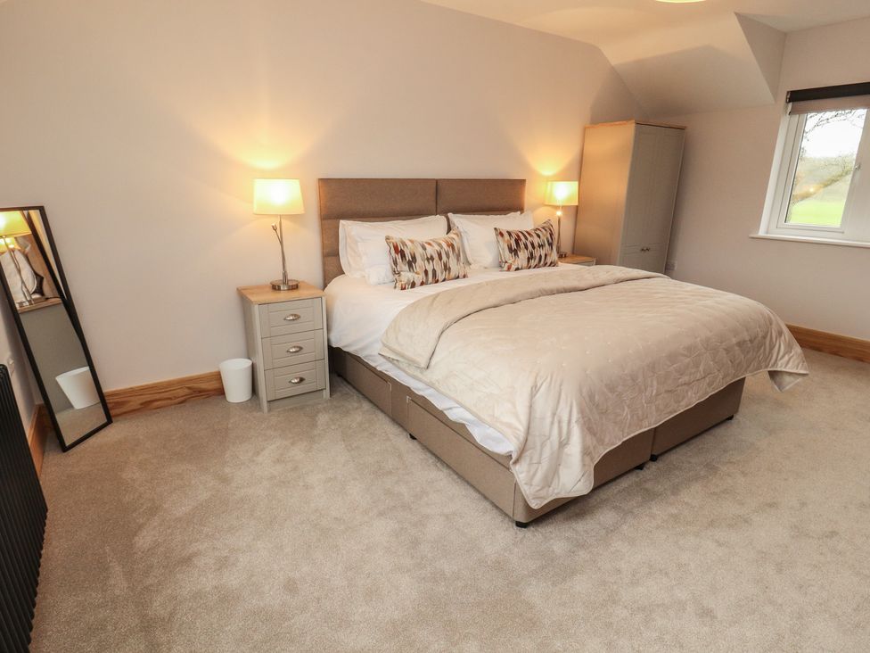 A bedroom with a bed and nightstand at The Gate House Annexe Cockermouth