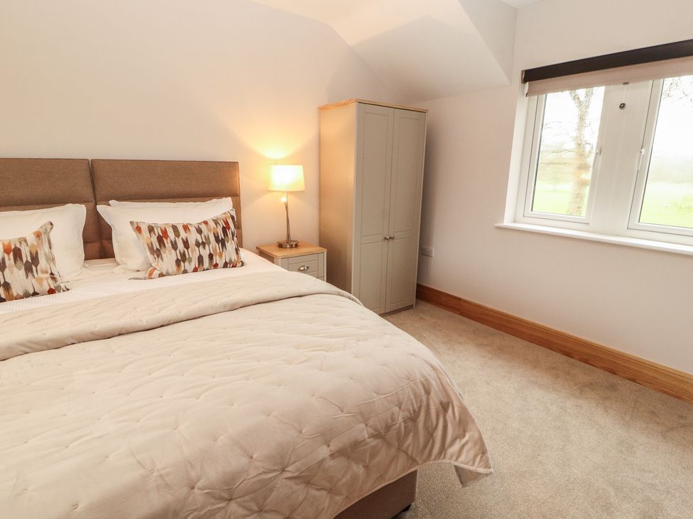 A bedroom with a bed and wardrobe at The Gate House Annexe Cockermouth