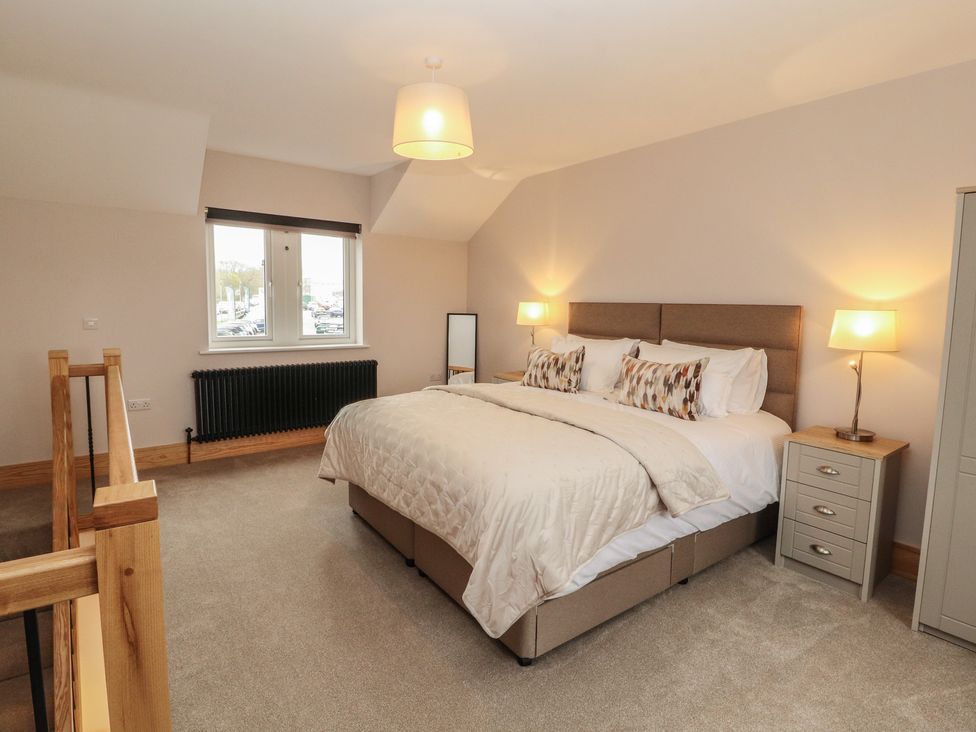 A bedroom with a bed and nightstand at The Gate House Annexe Cockermouth