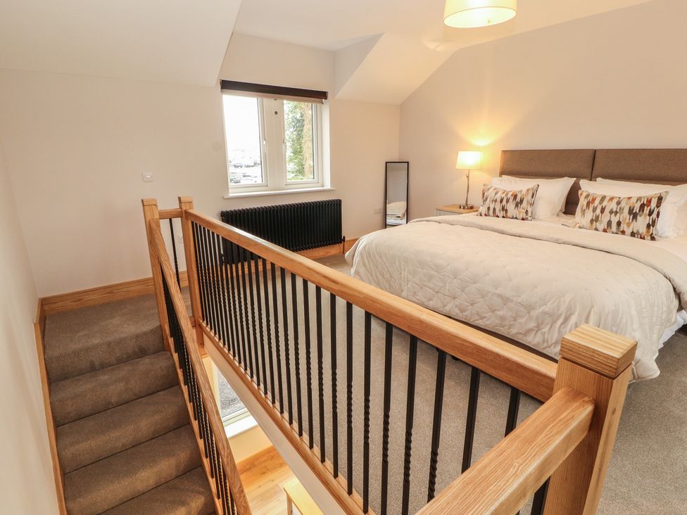 A bedroom with a bed and lamp at The Gate House Annexe in Cockermouth