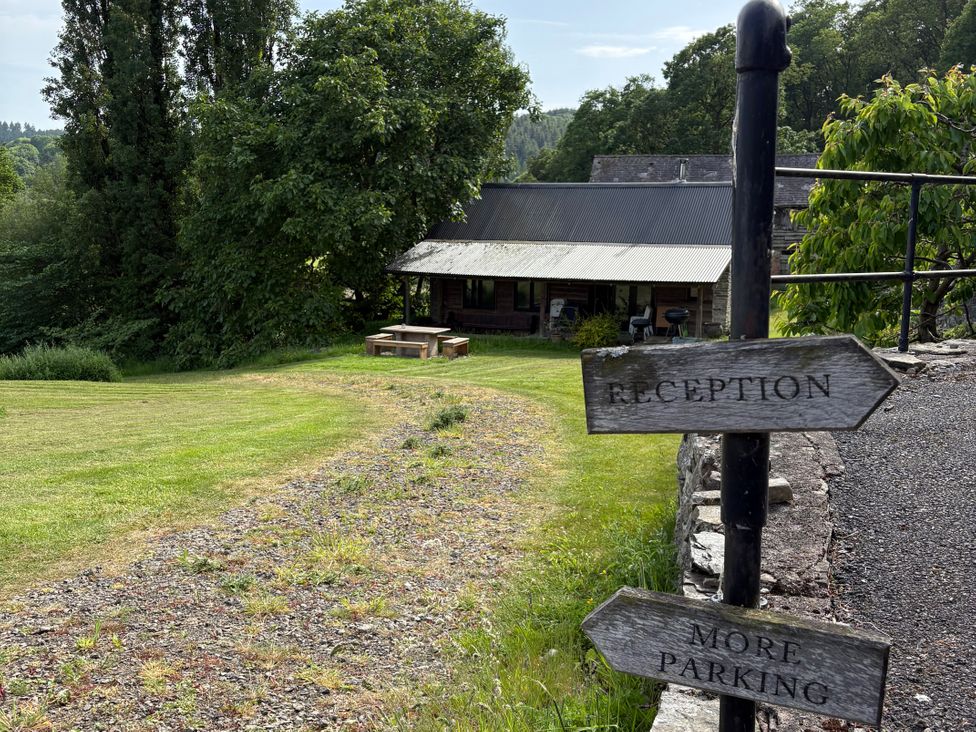 An outdoor area with signposts directing to reception and parking at Walnut Tree Lodge WITH hot tub Presteigne