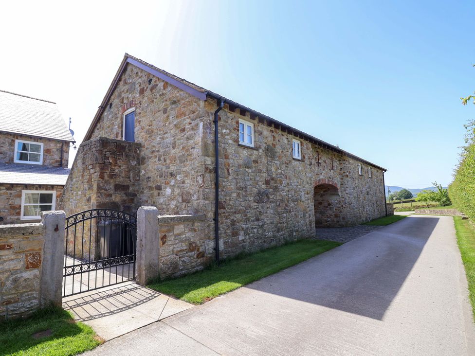 A stone building with a gated entrance and driveway at Pen Y Grisiau in Mold