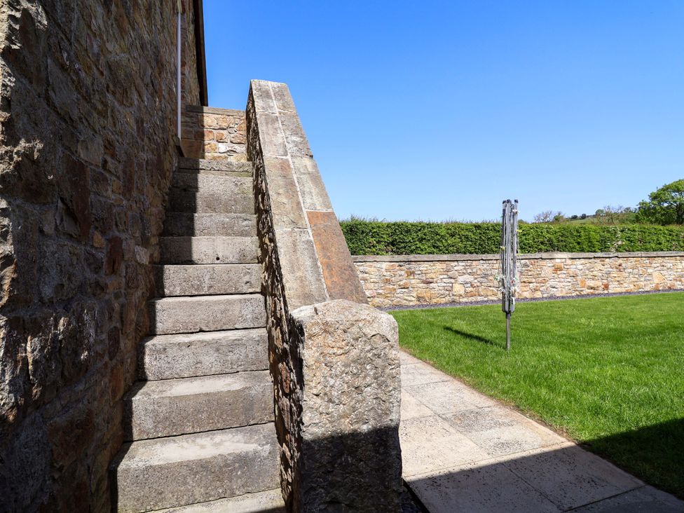 Stairs leading up to a stone wall in a garden at Pen Y Grisiau in Mold