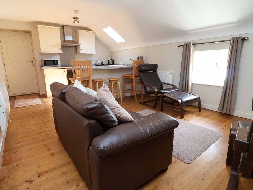 A living room with a sofa and dining area at Pen Y Grisiau in Mold