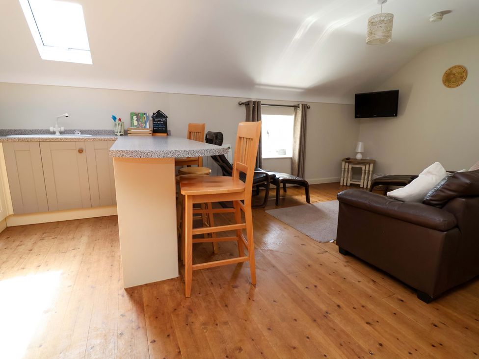 A living room with a kitchen area and seating at Pen Y Grisiau in Mold