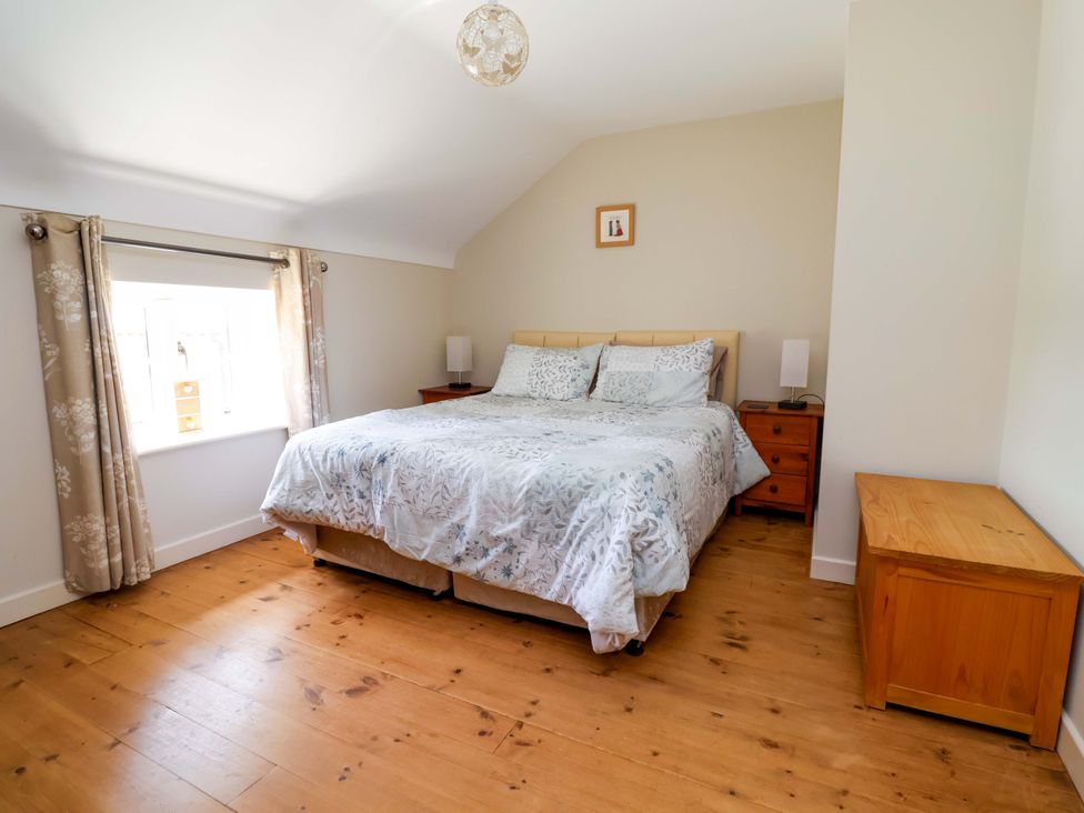 A bedroom with a bed and nightstand at Pen Y Grisiau in Mold