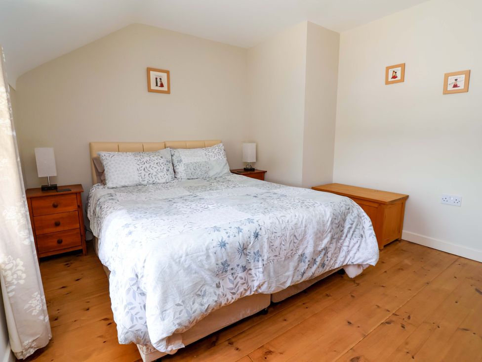 A bedroom with a bed and nightstands at Pen Y Grisiau in Mold