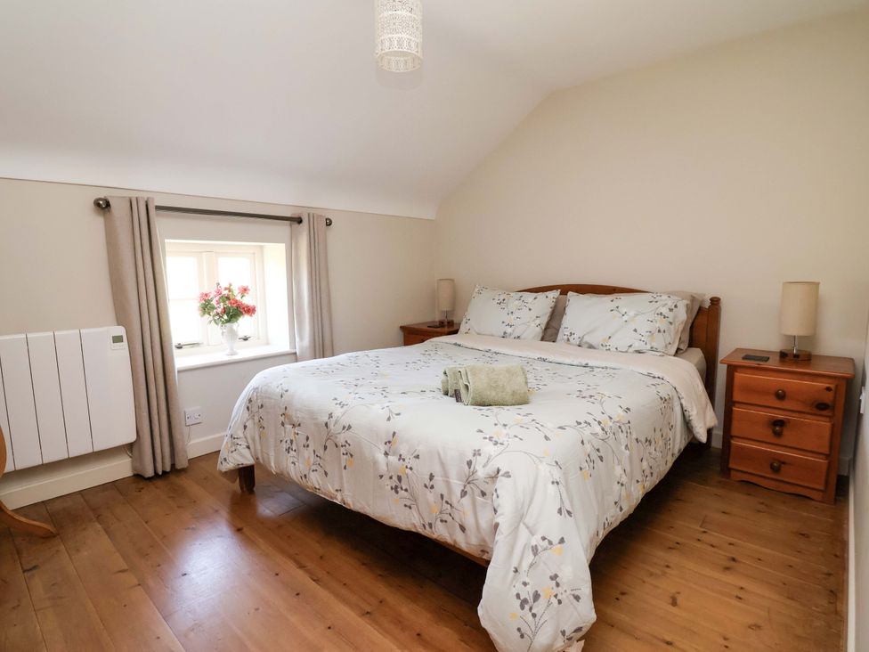 A bedroom with a bed and nightstand at Pen Y Grisiau in Mold