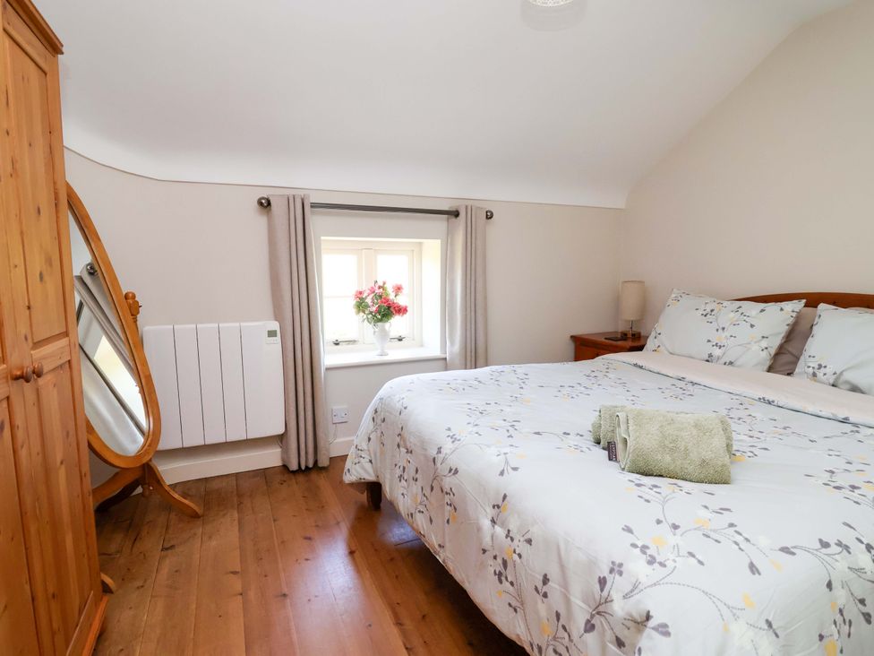 A bedroom with a bed, wardrobe, and window at Pen Y Grisiau in Mold
