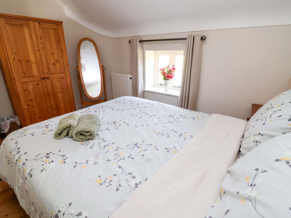 A bedroom with a bed and wardrobe at Pen Y Grisiau in Mold