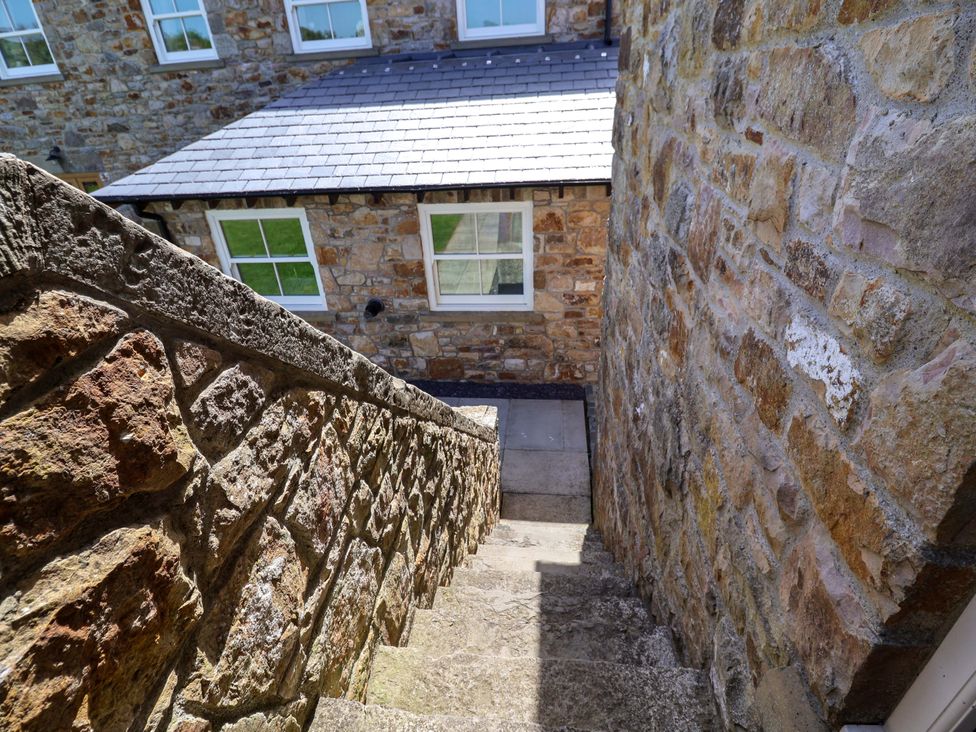 Stairs leading down beside stone walls at Pen Y Grisiau in Mold