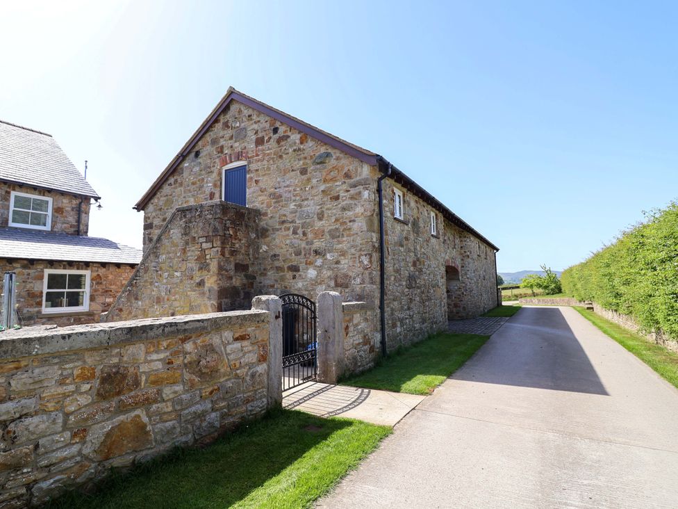A stone building with a gated entrance on a road at Pen Y Grisiau in Mold