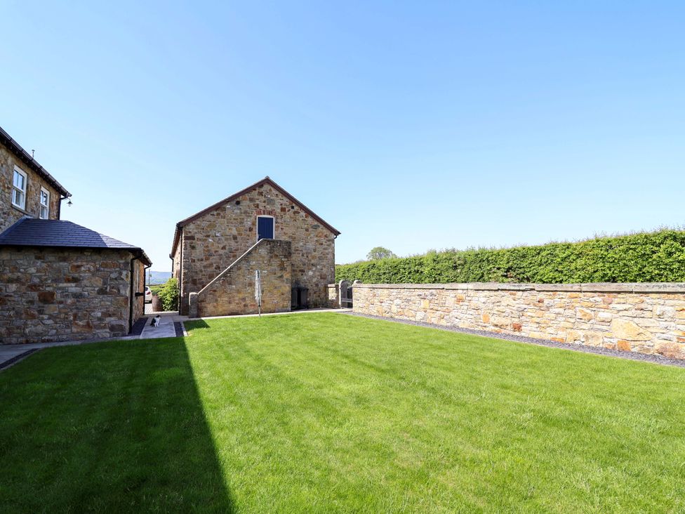 An outdoor area with a stone building and green lawn at Pen Y Grisiau, Mold