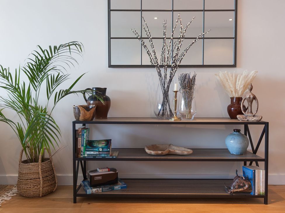 A shelf with plants and decorative items at Anchors Rest in St. Ives