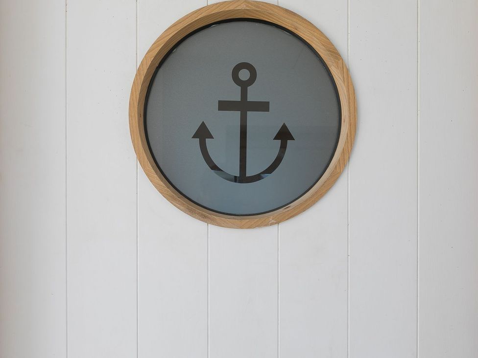 A round wall decoration featuring an anchor design at Anchors Rest in St. Ives