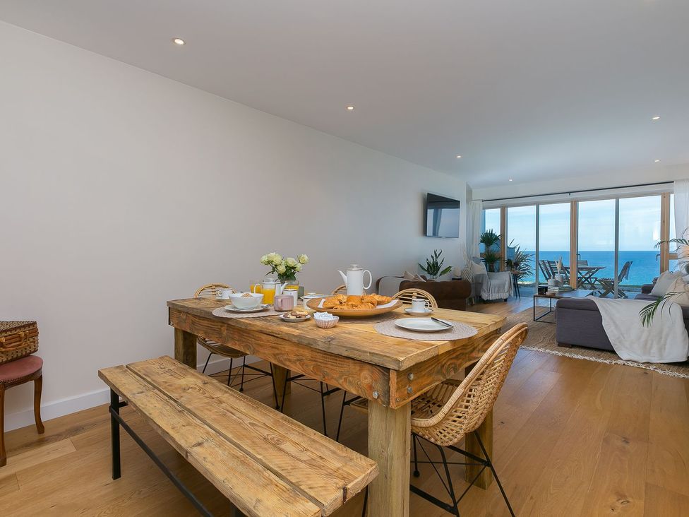 A dining room with a wooden table and chairs at Anchors Rest in St. Ives