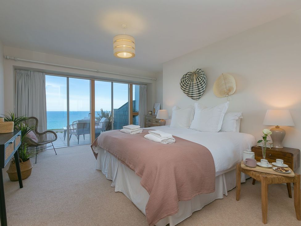 A bedroom with a bed and balcony view at Anchors Rest in St. Ives
