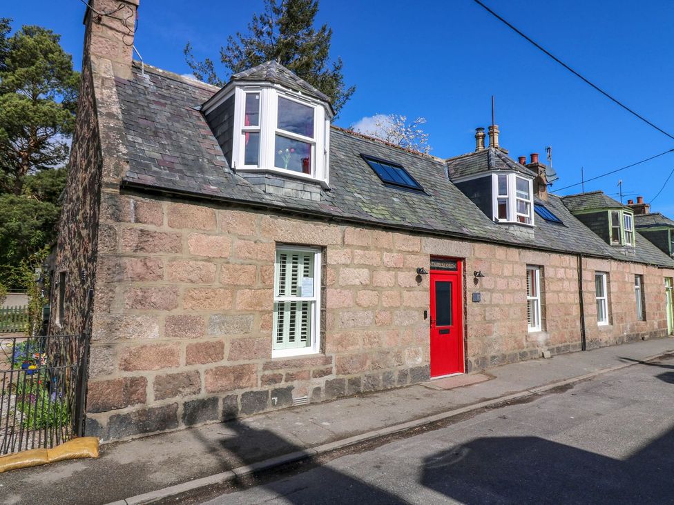 A stone house with a red front door at Evansford in Ballater