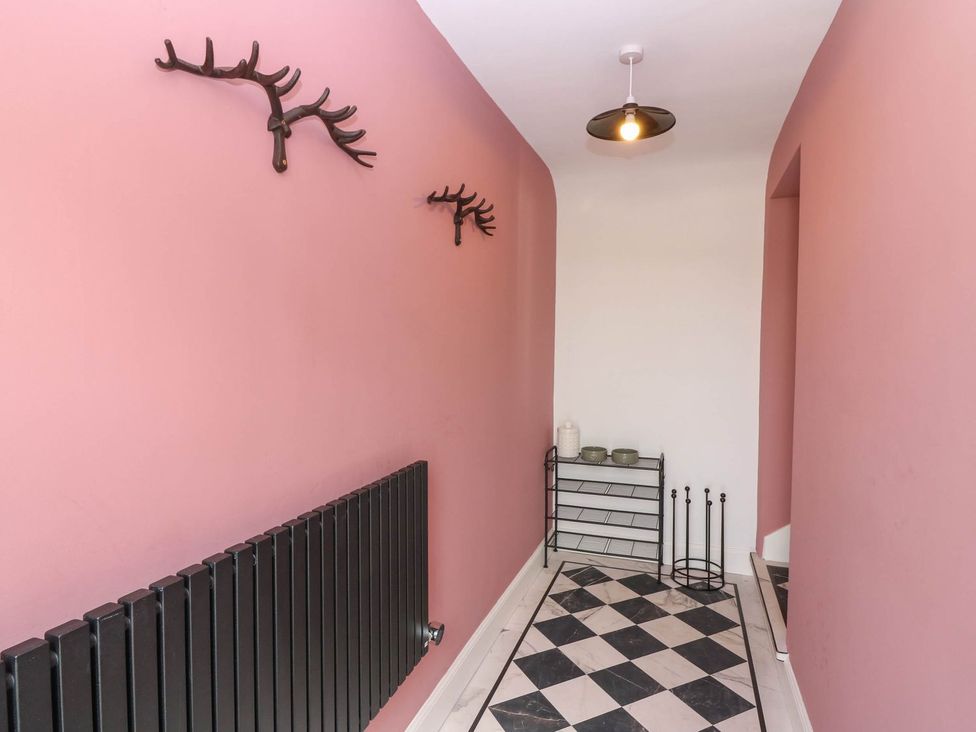 A hallway with antler decor and a radiator at Evansford in Ballater