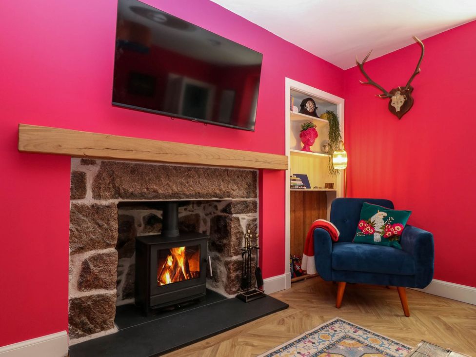 A living room with a fireplace and television at Evansford in Ballater