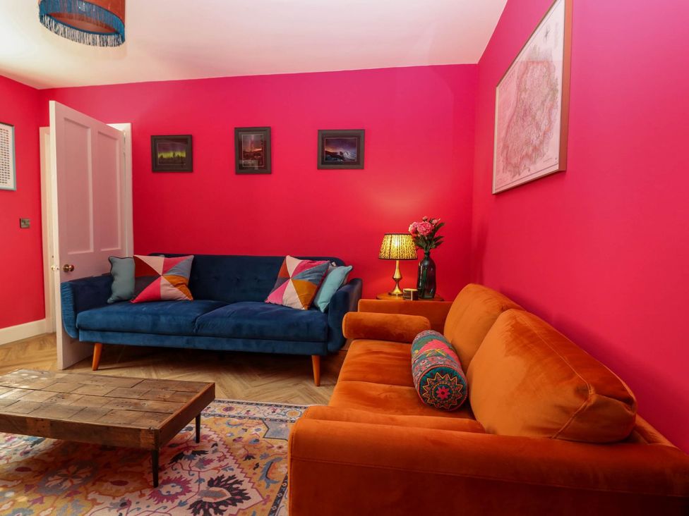 A living room with a blue sofa and orange sofa at Evansford in Ballater