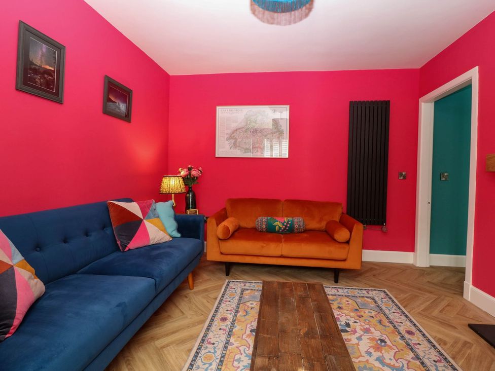 A living room with blue and orange sofas and a coffee table at Evansford in Ballater
