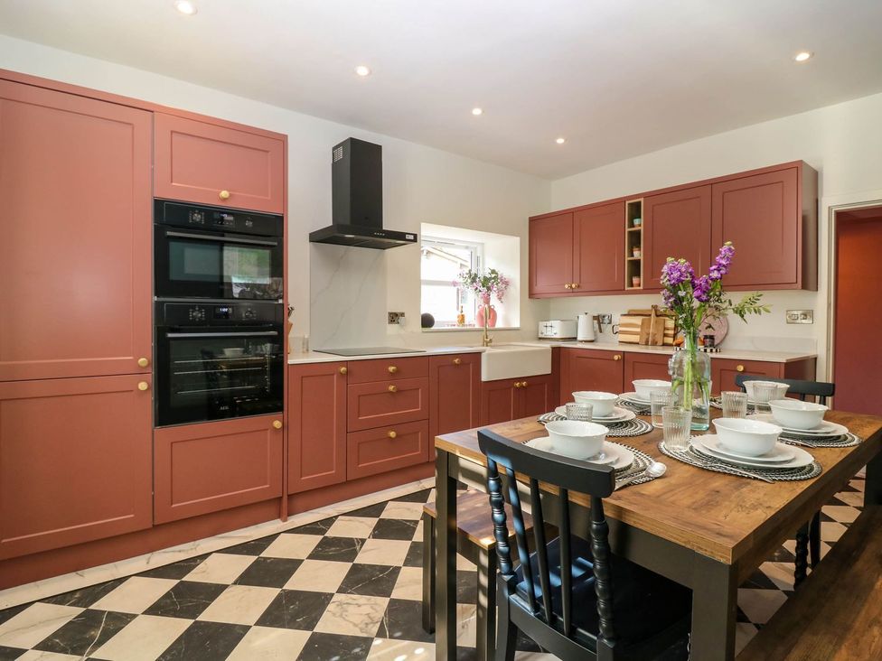 A kitchen with cabinets, appliances, and a dining table at Evansford in Ballater